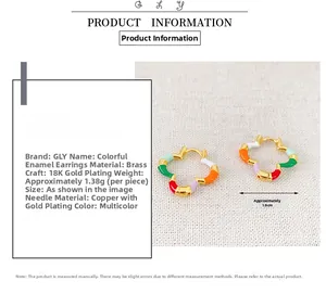 Dettaglio di orecchini a cerchio in bambù placcati oro 18K con fiori in smalto