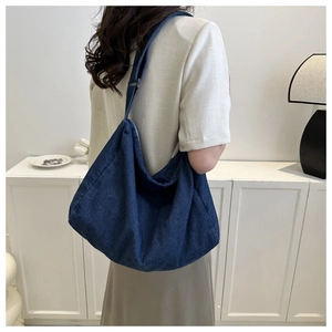 Grand sac cabas en denim bleu foncé porté au dos avec bandoulière réglable décontractée