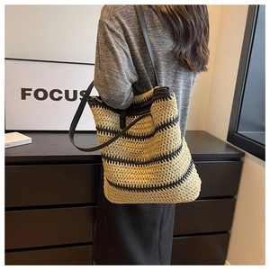 Lifestyle shot of a striped woven tote bag with slim shoulder straps and casual focus