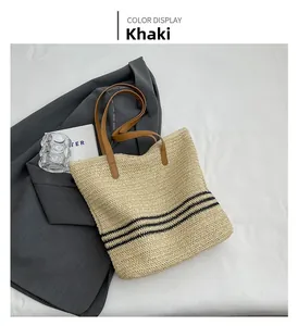 Detailed top view of a khaki woven tote bag with black stripes and brown leather handles