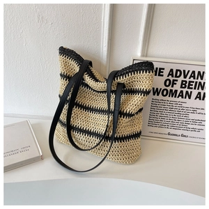 Close-up of woven tote bag with black and beige stripes and leather straps