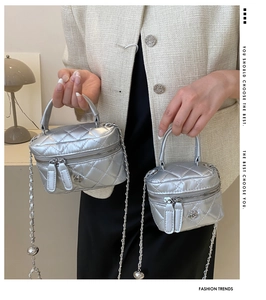 Detail view of mini silver quilted chain bags in two sizes with floral zipper accents