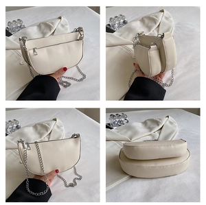 Detail view of beige crescent saddle bag with silver chain strap and mini pouch