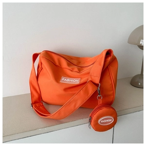 Dettaglio borsa a tracolla in nylon arancione con etichetta fashion e portamonete rotondo