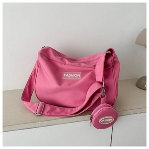 Dettaglio della borsa a tracolla in nylon rosa con borsellino rotondo e patch moda