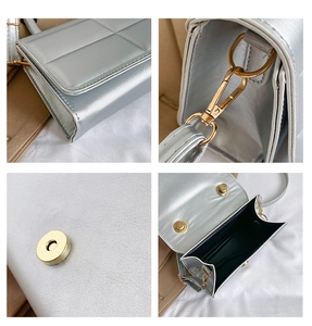Detail view of silver quilted crossbody bag with gold magnetic buckle and lobster clasp