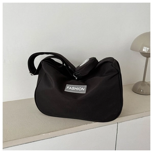 Dettaglio borsa a mezzaluna in nylon nero con portamonete e etichetta FASHION