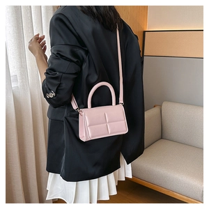 Quilted light pink crossbody bag shown in a cozy indoor lifestyle setting