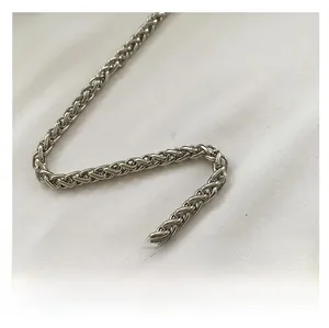Detail shot of the polished silver metal woven chain strap with intricate mesh texture