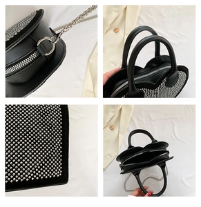 Detail view of heart-shaped crossbody bag featuring silver studs and metal chain strap