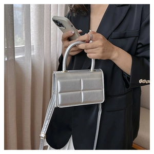 Silver quilted crossbody bag shown with a modern black blazer for a stylish urban look