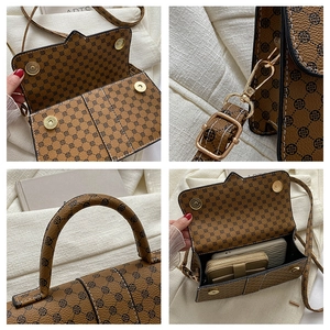 Detailoverzicht van bruine vintage handtas met gouden hardware en ruime binnenkant