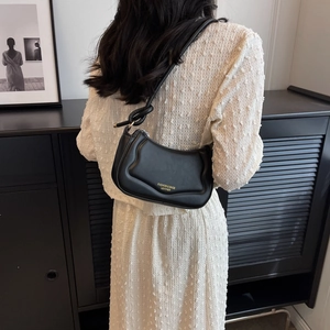 Minimalistische schwarze Leder-Satteltasche mit stilvollem Knotengurt und Goldschrift