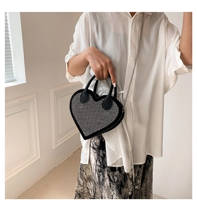 Detail of a heart-shaped bag with sparkling rhinestones and a silver metal chain strap