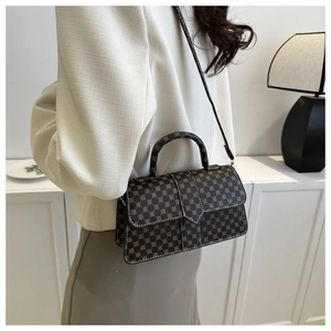 Klassieke monogram schoudertas met geometrisch patroon en elegante witte blazer