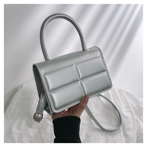 Detailed macro view of silver quilted handbag with metallic pearl finish and texture