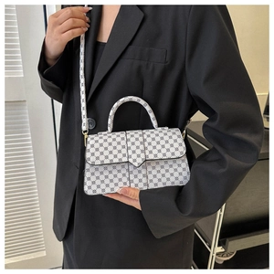 Modieuze handtas met polkadots op model met verstelbare riem en gouden metalen details