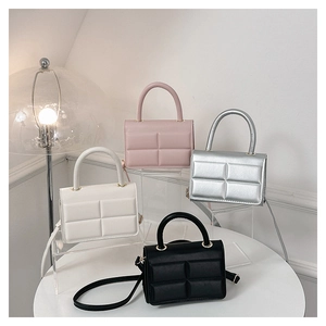 Close-up of four quilted mini square bags in pink, silver, white, and black colors
