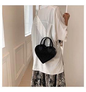 Detail of sparkling heart-shaped handbag with chain strap styled in modern interior