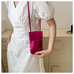 Glossy magenta vertical mobile phone crossbody bag worn with a white dress