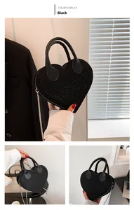 Detail of black heart-shaped handbag with sparkling rhinestones and silver chain strap