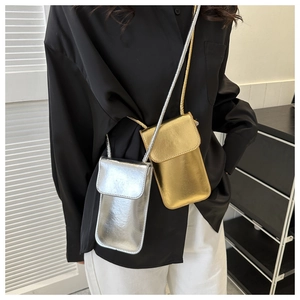 Détail de mini sacs à bandoulière métallisés argent et or portés par un mannequin