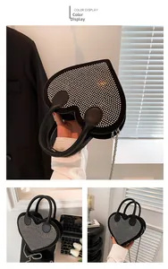 Close-up of heart-shaped handbag with dense silver rhinestones and metal chain strap
