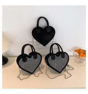 Detail of heart-shaped rhinestone handbags with leather handles and silver chain straps