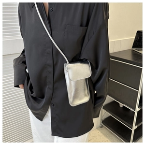 Mini sac à bandoulière argenté métallisé pour téléphone porté avec une tenue noir et blanc