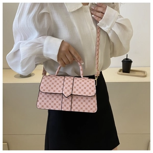 Detail van roze monogram tas met handvat en schouderband gedragen door een model