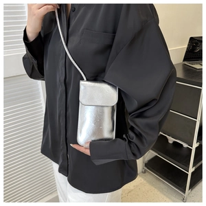 Glänzende silberne Mini-Umhängetasche für Handys am Model mit schmalem Schultergurt