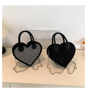 Detailed view of heart-shaped rhinestone handbags in black and silver with chain straps