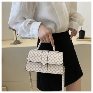 Detail van beige crossbodytas met geometrisch patroon en ronde handgreep bovenaan