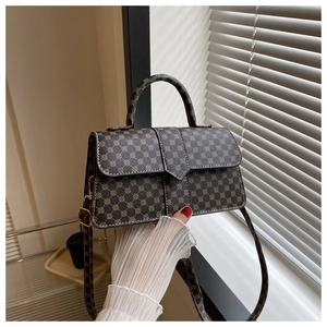 Detail van vintage geometrisch patroon en handvat van bruine crossbody tas