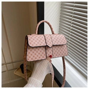 Detail van roze vintage handtas met geometrische print, handvat en een schouderriem