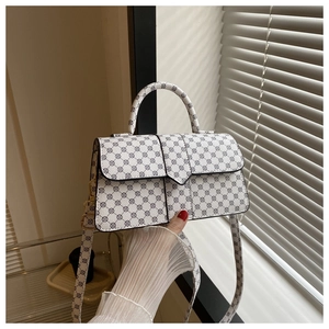 Detail van grijze crossbodytas met geometrisch patroon tegen een shutterachtergrond