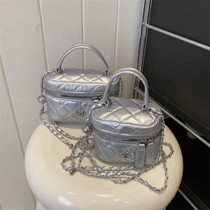 Mini borsa vanity argentata trapuntata con tracolla a catena e dettaglio camelia