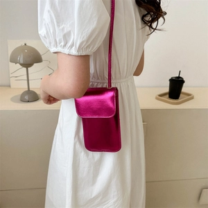 Minimalistische metallische fuchsia Handytasche getragen auf einem weißen Kleid