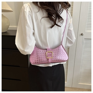 Détail du sac baguette en cuir verni rose avec motif étoilé et boucle dorée élégante