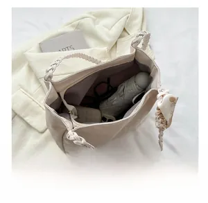 Top view of large capacity cream tote bag showing daily essentials and woven strap