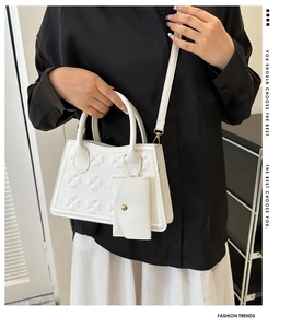 Detail van witte crossbodytas met klaverreliëf en bijpassende kleine muntenzakje