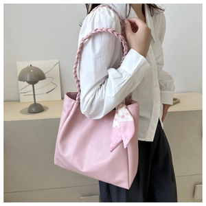 Pink tote bag detail with woven handle and polka dot silk scarf in home setting