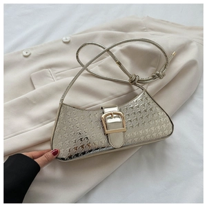 Détail du sac argenté métallisé avec gaufrage étoile et boucle sur blazer beige