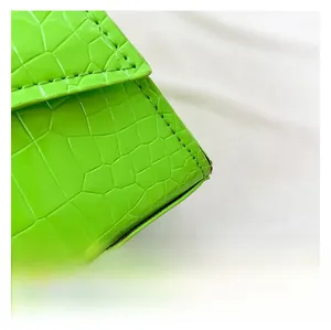 Detail view of vibrant green crocodile-embossed leather with high-quality stitching