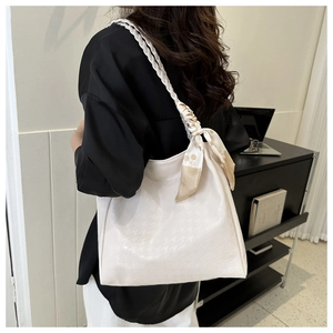 Detail of off-white houndstooth tote bag with woven shoulder strap and silk scarf