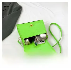 Detail shot of green crocodile texture handbag interior showcasing large storage capacity