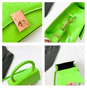 Detail of neon green crocodile embossed handbag with gold hardware and woven handle