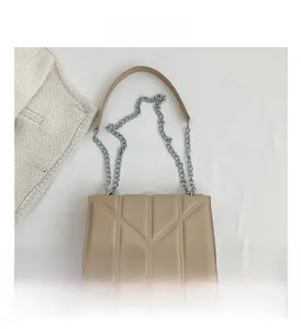 Detail shot of beige quilted PU leather crossbody bag with silver chain strap and padding