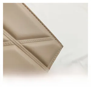 Close-up of beige quilted leather detail with diagonal stitching on crossbody bag