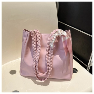 Detailed shot of pink PU leather tote with woven handles and decorative silk scarf